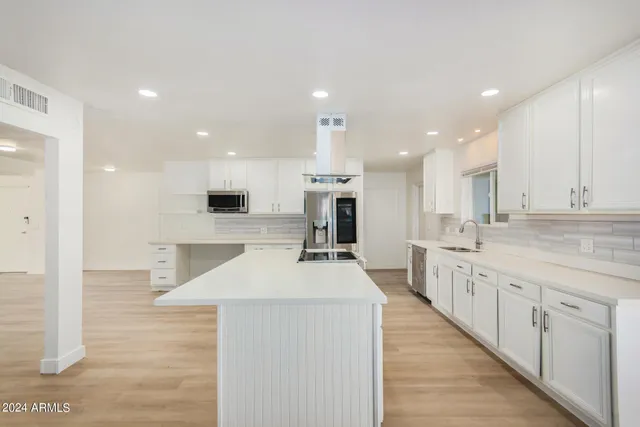 a large kitchen with stainless steel appliances kitchen island a stove a sink a refrigerator and a sink