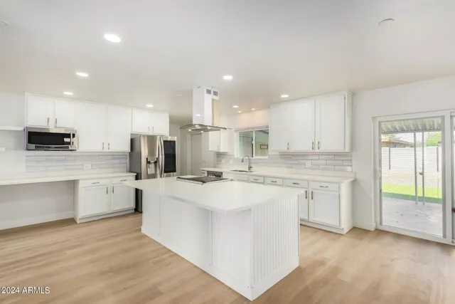 a large kitchen with cabinets and stainless steel appliances