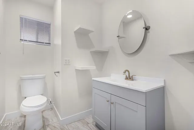 a bathroom with a sink a toilet and a mirror