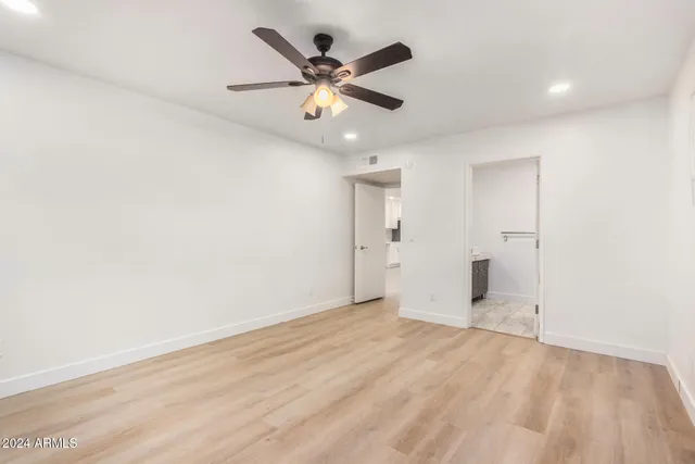 an empty room with closet and windows