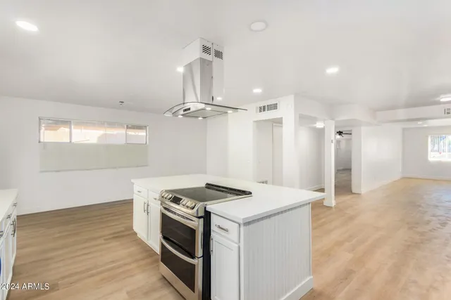 a kitchen that has a sink a stove and wooden floor