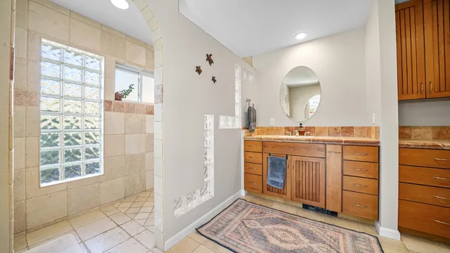 a spacious bathroom with a double vanity sink a mirror and a bathtub