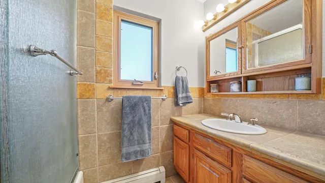 a bathroom with a granite countertop sink and a mirror
