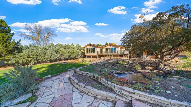 a view of a table and chairs in the garden in front of house