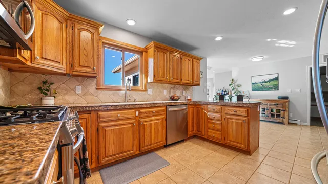 a kitchen with stainless steel appliances granite countertop wooden cabinets a sink and dishwasher