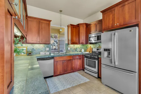 a kitchen with stainless steel appliances granite countertop cabinets and window