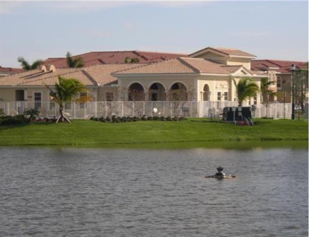 9082 Plymouth Place, Unit 9082 Tamarac, FL 33321 - Photo 12 of 47 a front view of a house with a yard and garage