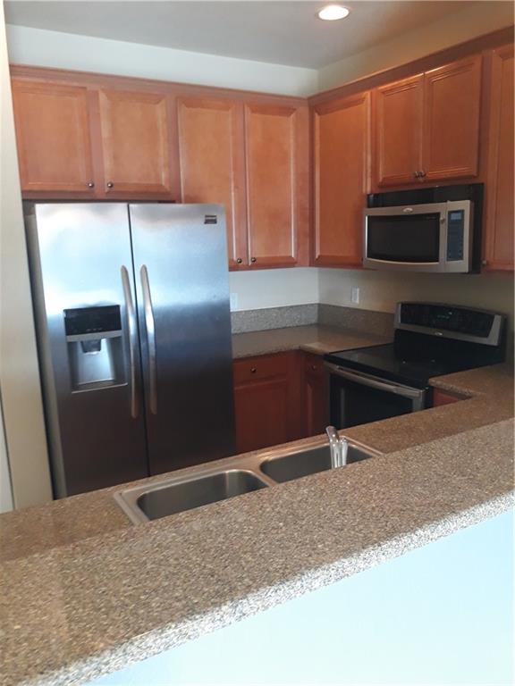 9082 Plymouth Place, Unit 9082 Tamarac, FL 33321 - Photo 24 of 47 a kitchen with granite countertop a refrigerator and a sink