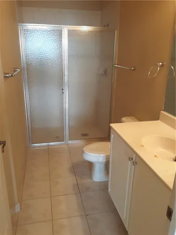a bathroom with a granite countertop sink a toilet and shower