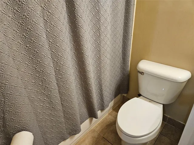 a white toilet sitting next to a white wall