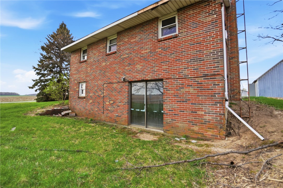 9750 Middlepoint Road Middle Point, OH 45863 - Photo 39 of 43 This brick exterior features a walk-out basement and a view of the surrounding landscape.