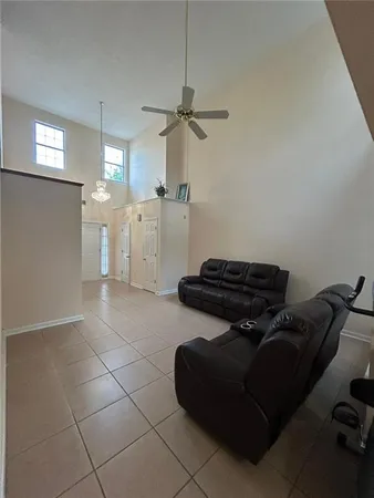 a living room with furniture and a ceiling fan