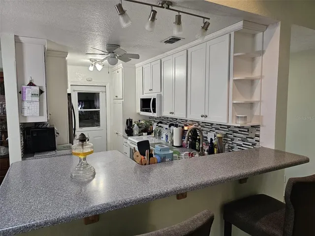 a kitchen with a sink a counter and chairs