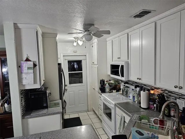 a view of a kitchen with a sink and a refrigerator