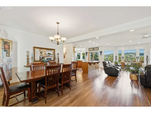 a view of a dining room and livingroom with furniture wooden floor a chandelier