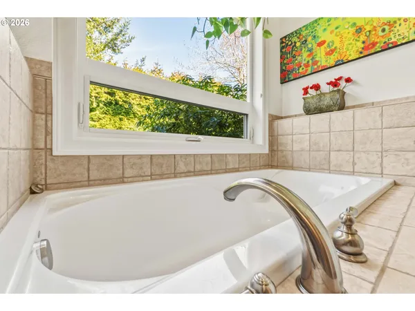 a bathroom with a sink double vanity granite tub shower and mirror