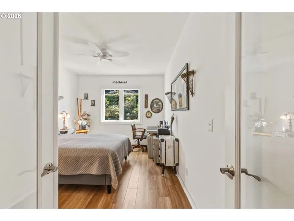 a bedroom with a bed a chandelier and a window