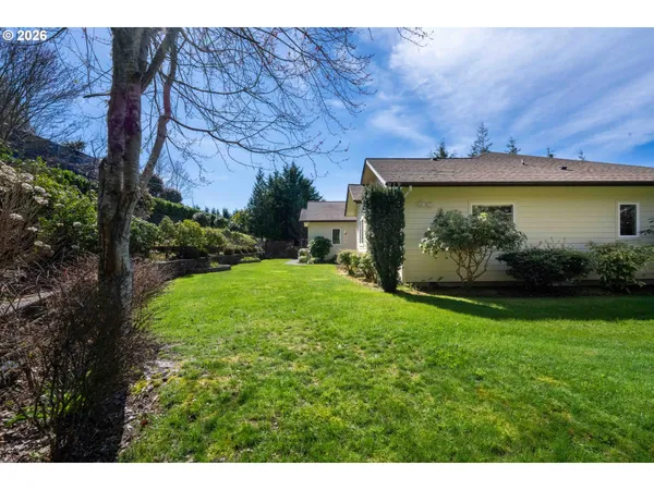 a view of a house with potted plants and a table and chairs