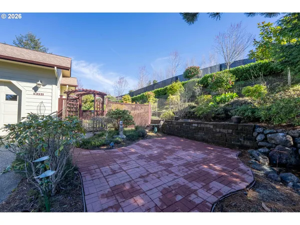 a view of a garden with plants and large trees