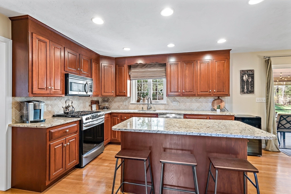 23 Northern Spy Road Franklin, MA 02038 - Photo 11 of 41 a kitchen with kitchen island granite countertop wooden cabinets a counter top space a sink and appliances