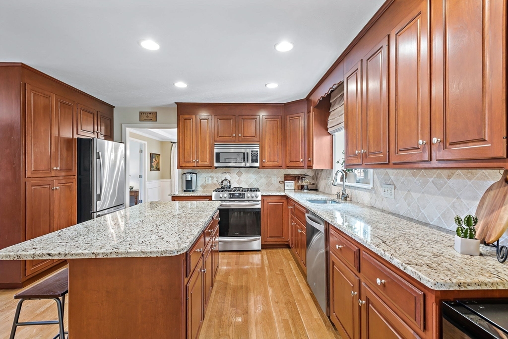 23 Northern Spy Road Franklin, MA 02038 - Photo 12 of 41 a kitchen with stainless steel appliances granite countertop a refrigerator a sink dishwasher a stove and a kitchen island with wooden floor