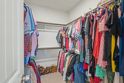 a view of walk in closet with clothes