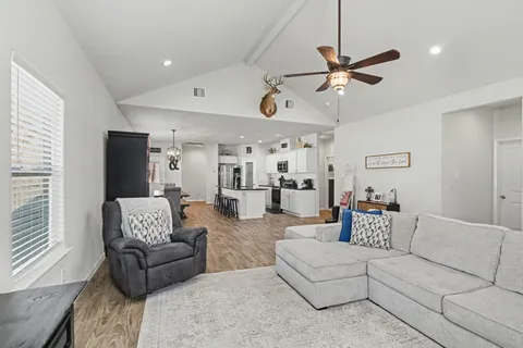 a living room with furniture and a ceiling fan