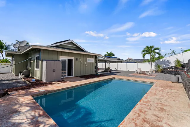 a view of a house with pool and sitting area