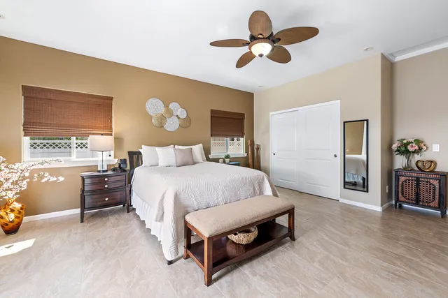 a spacious bedroom with a bed and a chandelier