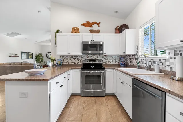 a kitchen with stainless steel appliances a stove sink and cabinets