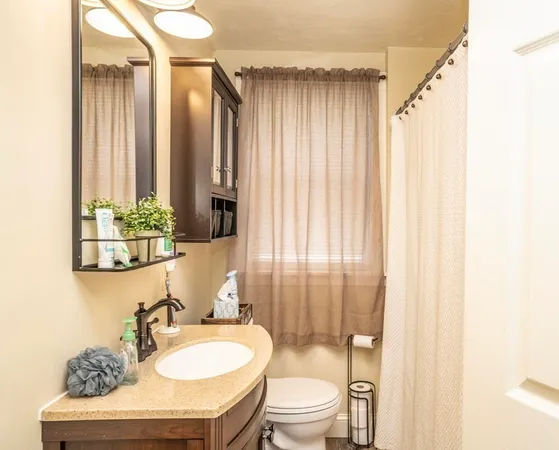 a bathroom with a granite countertop sink toilet a mirror and shower