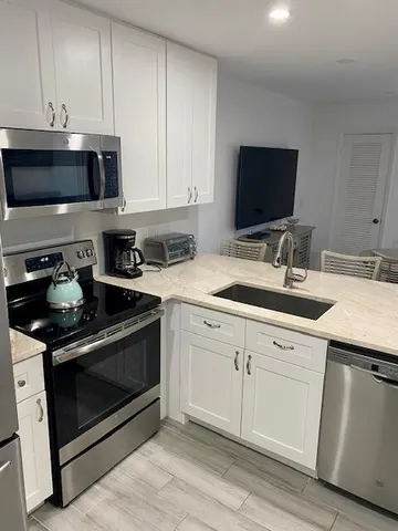 a kitchen with stainless steel appliances granite countertop a sink stove and microwave