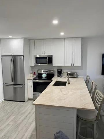 a kitchen with a refrigerator a stove a microwave and white cabinets