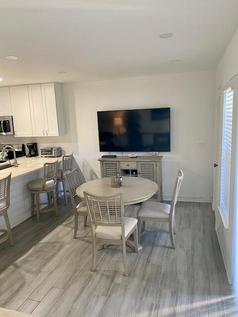 1605 Highway 1, Unit V2106 Jupiter, FL 33477 - Photo 6 of 18 a view of a dining room with furniture and wooden floor