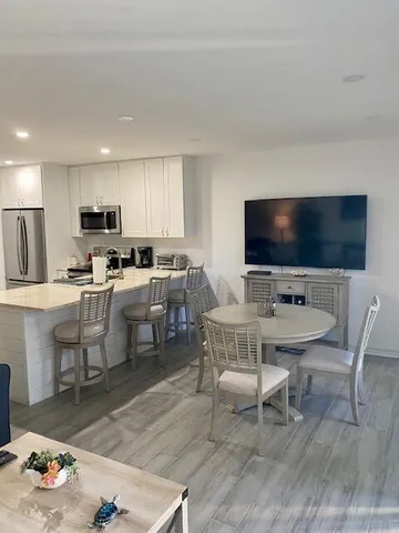 a living room with furniture a flat screen tv and kitchen view