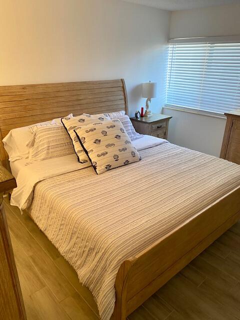 1605 Highway 1, Unit V2106 Jupiter, FL 33477 - Photo 10 of 18 a bed sitting in a bedroom next to a window with a lamp