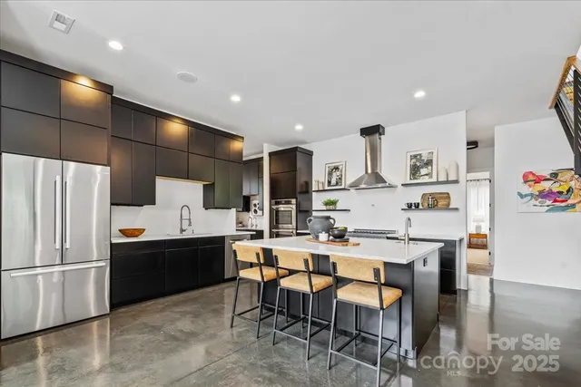 a kitchen with refrigerator and chairs