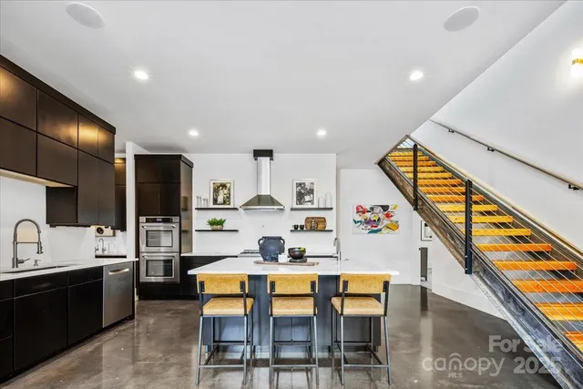 a kitchen with stainless steel appliances kitchen island granite countertop a sink and cabinets