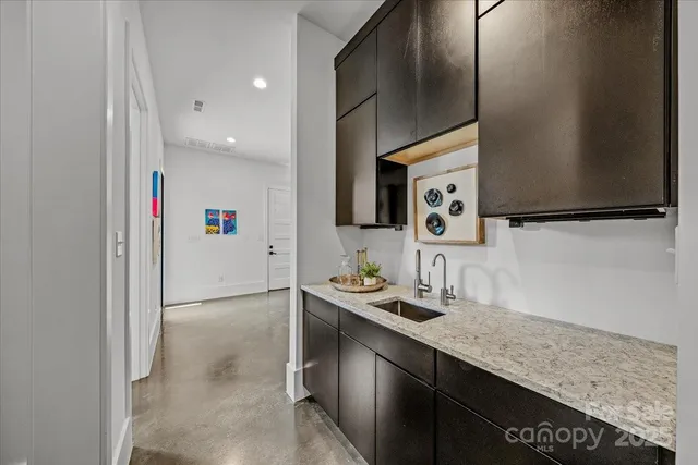 a kitchen with stainless steel appliances granite countertop a sink and a refrigerator