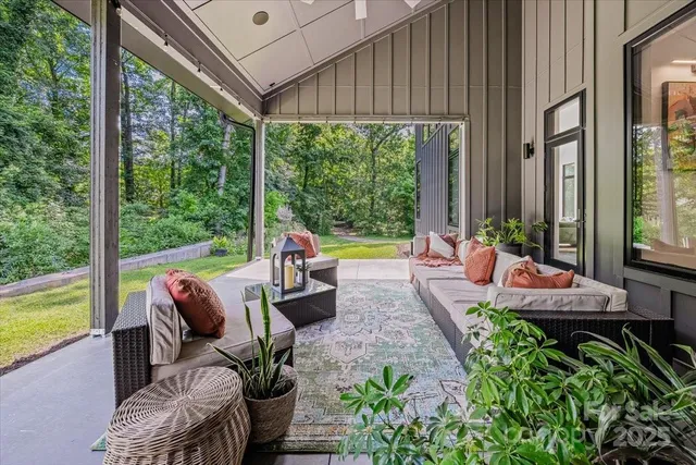 a view of a patio with couches chairs potted plants and floor to ceiling window yard