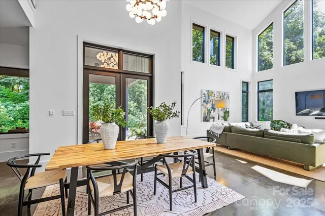 a dining room with furniture a large window and a chandelier