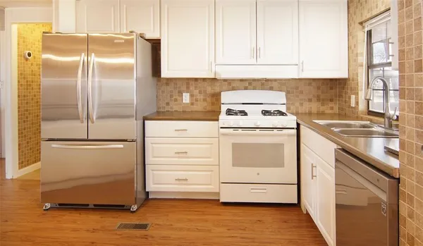 a kitchen with a refrigerator sink stove and cabinets