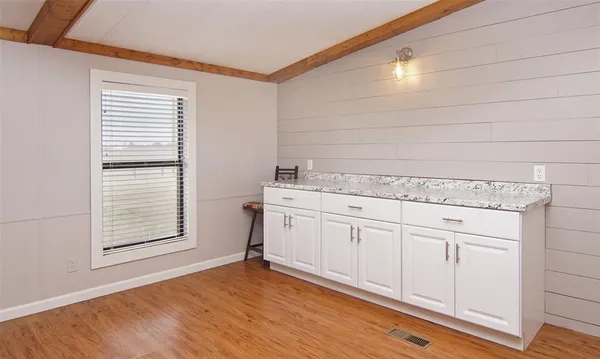 a view of a kitchen sink and dishwasher with wooden floor