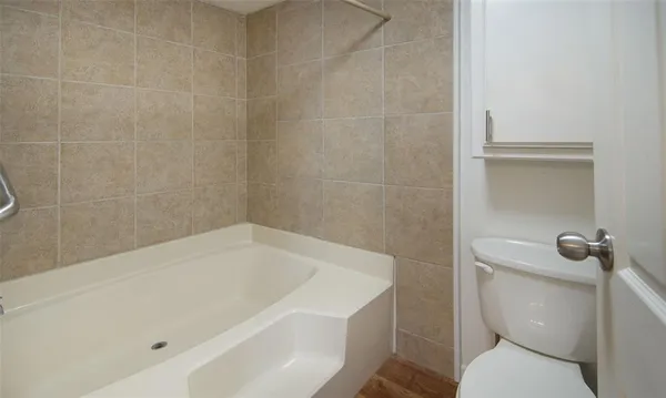 a white bath tub sitting next to a toilet