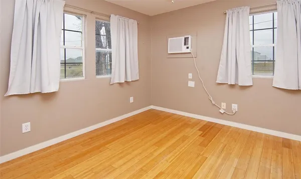a view of a room with wooden floor and windows