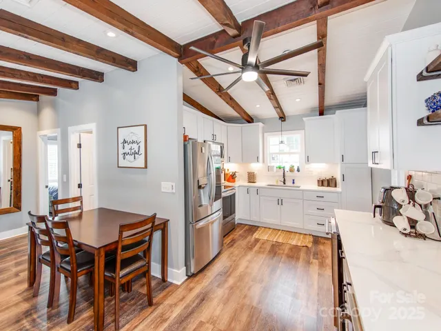 a kitchen with stainless steel appliances kitchen island granite countertop a sink cabinets and wooden floor