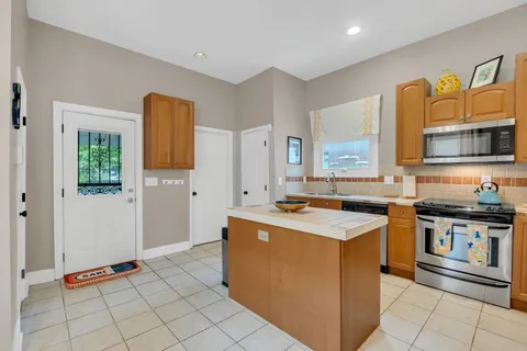 a kitchen with stainless steel appliances granite countertop a stove a sink and a microwave
