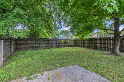 a view of a yard with a wooden fence