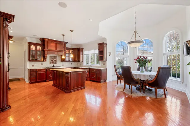 a living room with stainless steel appliances kitchen island granite countertop a dining table chairs and a large window