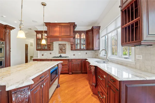 a kitchen with stainless steel appliances granite countertop a sink a stove and a wooden floors